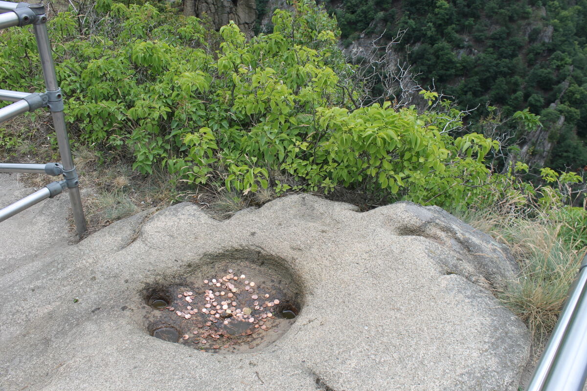 Die Vertiefung im Granit an der Rosstrappe, randvoll mit Münzen. Der Sage nach ist es der Hufabdruck von Brunhildes Pferd, das über die Schlucht sprang